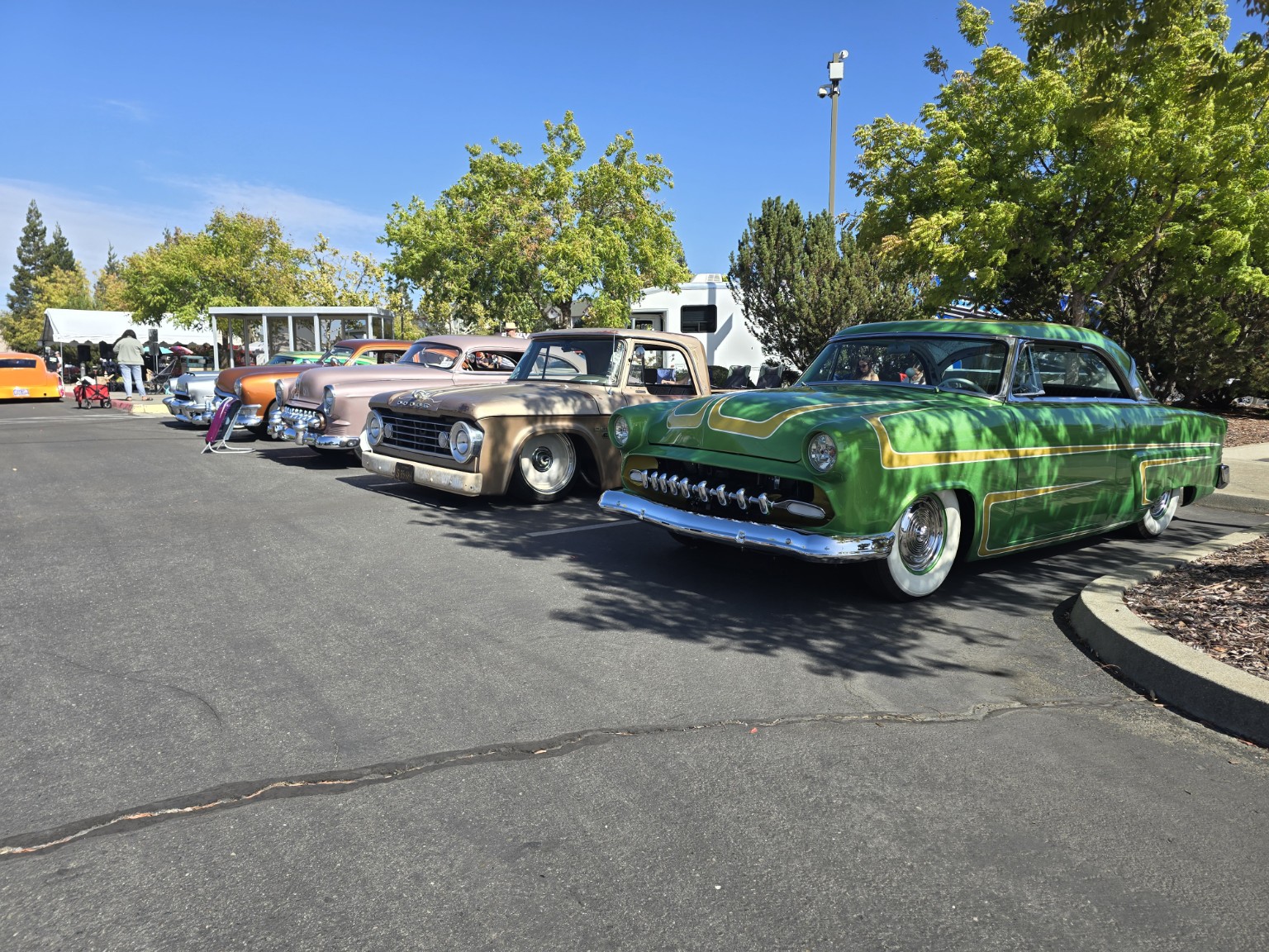 Green scalloped custom, lowered pickup, and a row of colorful custom cars at Autoberfest