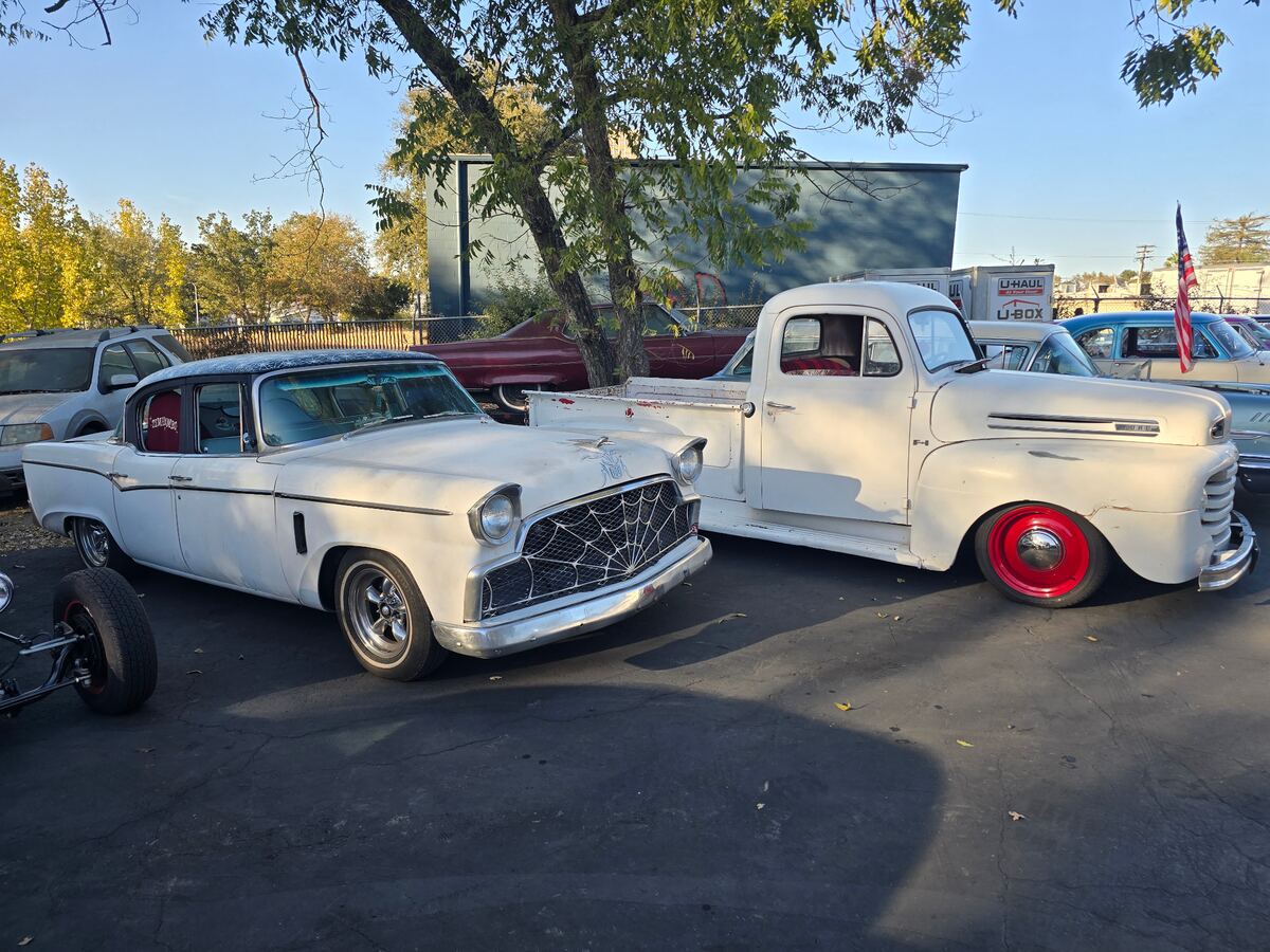 White custom car and white pickup with red wheels parked together
